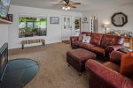 Centrally located living area with leather couch & chair, and TV